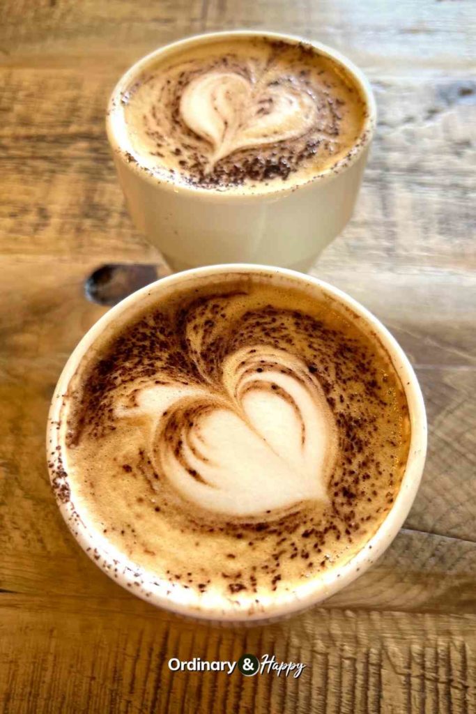 Cappuccinos on a wooden table.