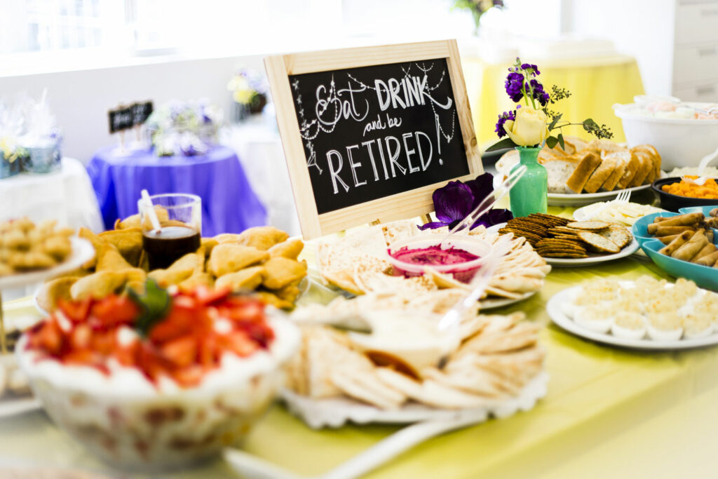 Snack and dessert table with a retirement party sign on it