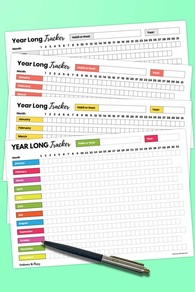 4 different colored year long tracker printables laid out on a plain background