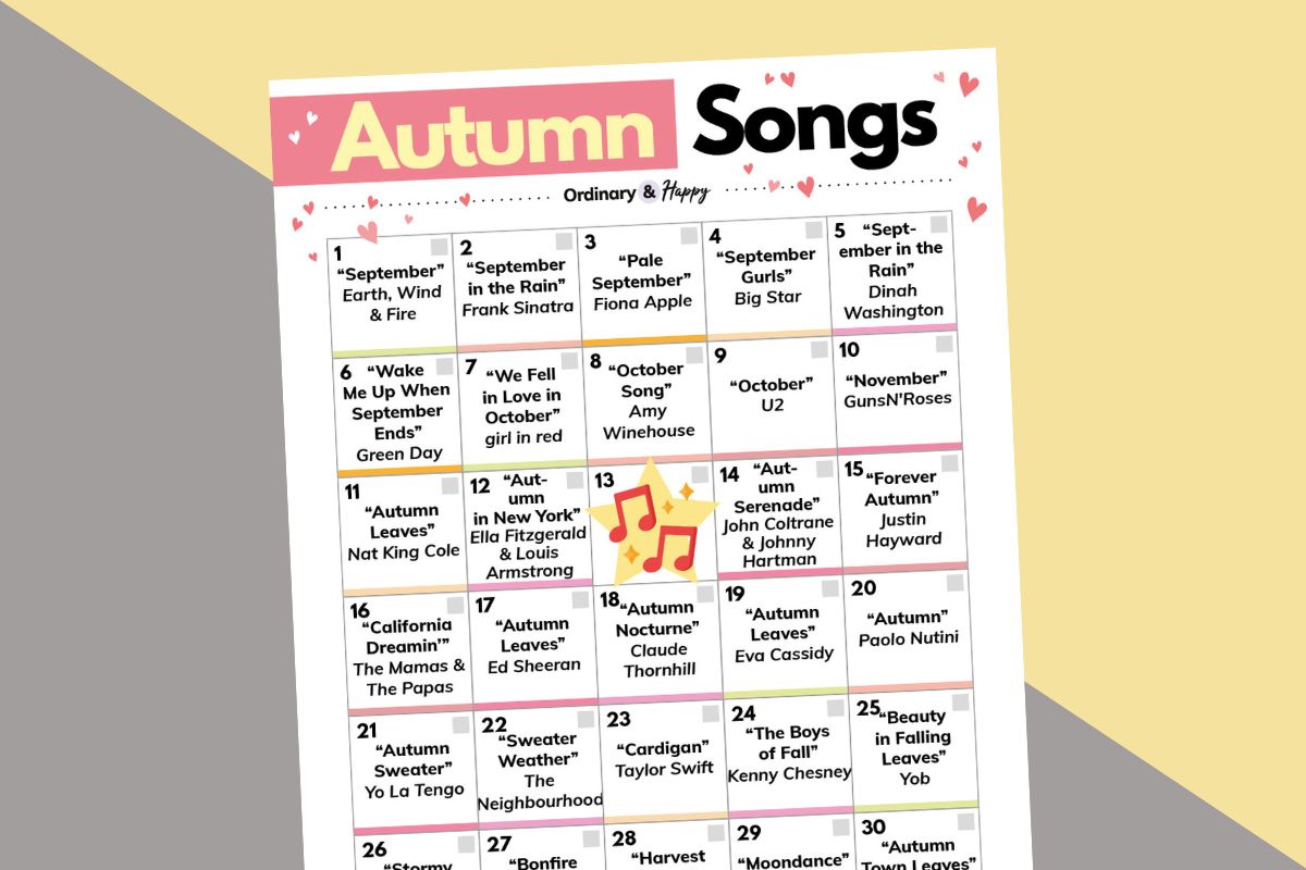 bingo card of 29 autumn songs with black text on white, displayed against a 2-color diagonal pink and orange background